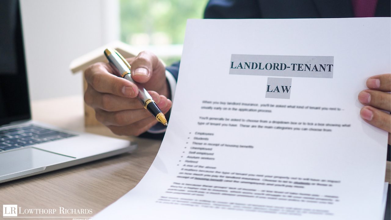 a lawyer pointing to a paper titled "Landlord-Tenant Law"